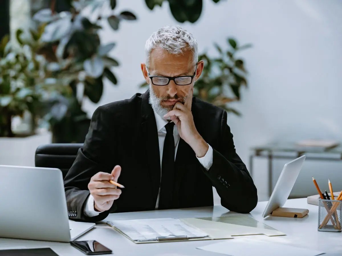 Banking executive studying paperwork at his desk.